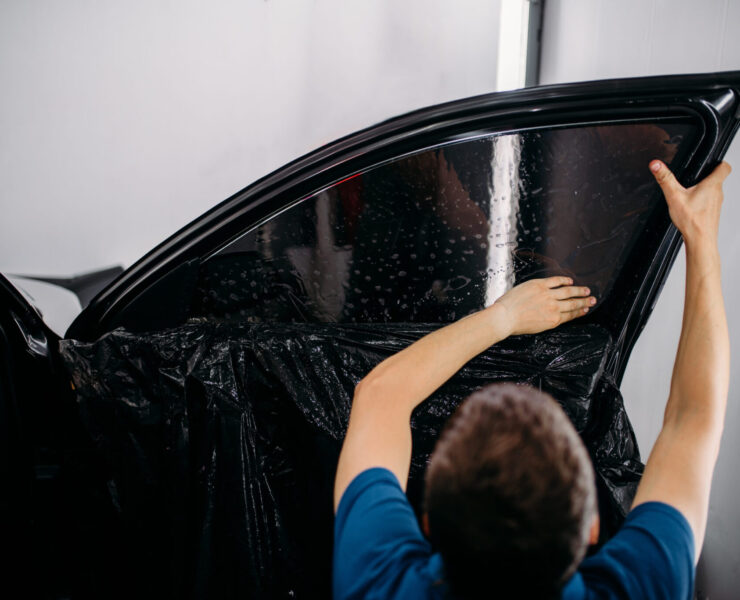 Male specialist with drier, car tinting film installation process, tinted auto glass installing procedure